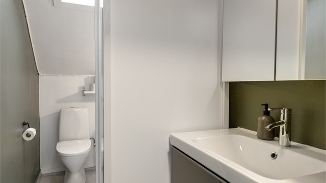Lyst og funksjonelt bad med takvindu som gir godt dagslys. Praktisk planløsning med dusjkabinett, moderne servantinnredning, toalett og opplegg for vaskemaskin.