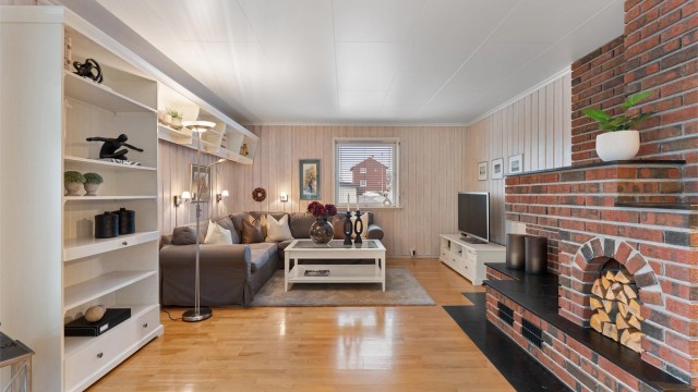 Stuen har god plass til en stor sofagruppe og er innredet med malt panel og takplater.
