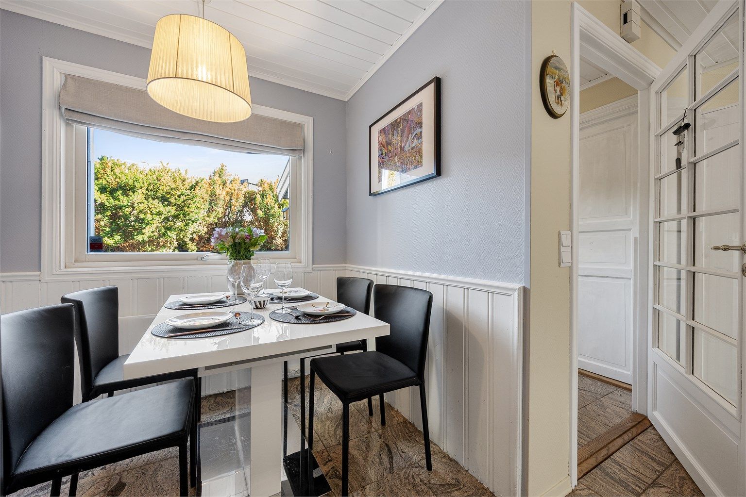 Veggpanel og lyst listverk rammer inn spisekroken på kjøkkenet.