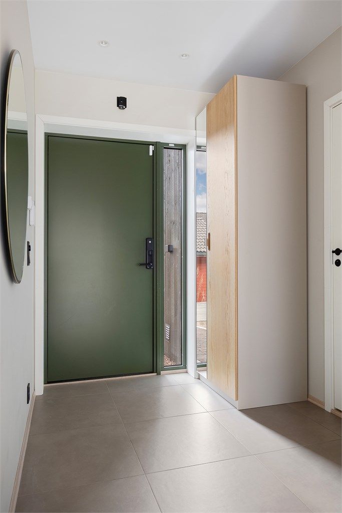 Velkommen inn i en lys entré med fliser på gulvet og innfelt LED-belysning i taket.