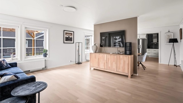 Stuen er malt i lyse farger og har store vinduer som sørger for godt lysinnslipp.