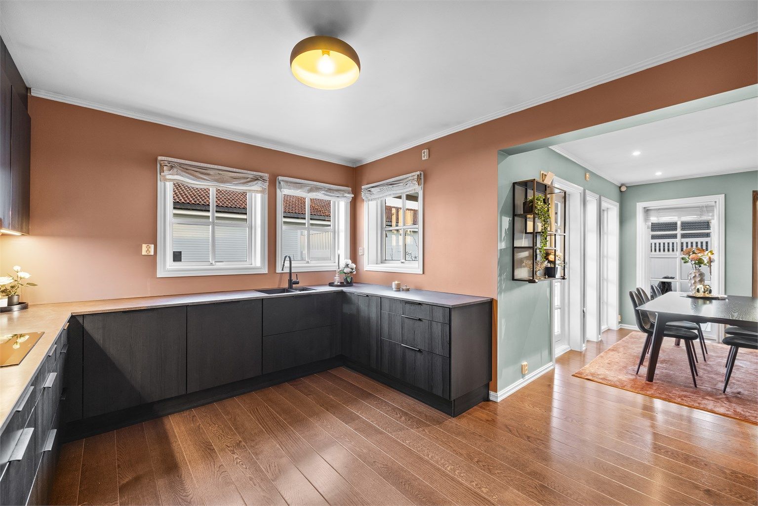 Den åpne løsningen binder kjøkkenet sammen med spisestuen og skaper en sosial og luftig atmosfære.