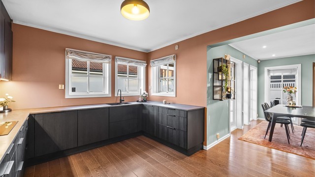 Den åpne løsningen binder kjøkkenet sammen med spisestuen og skaper en sosial og luftig atmosfære.