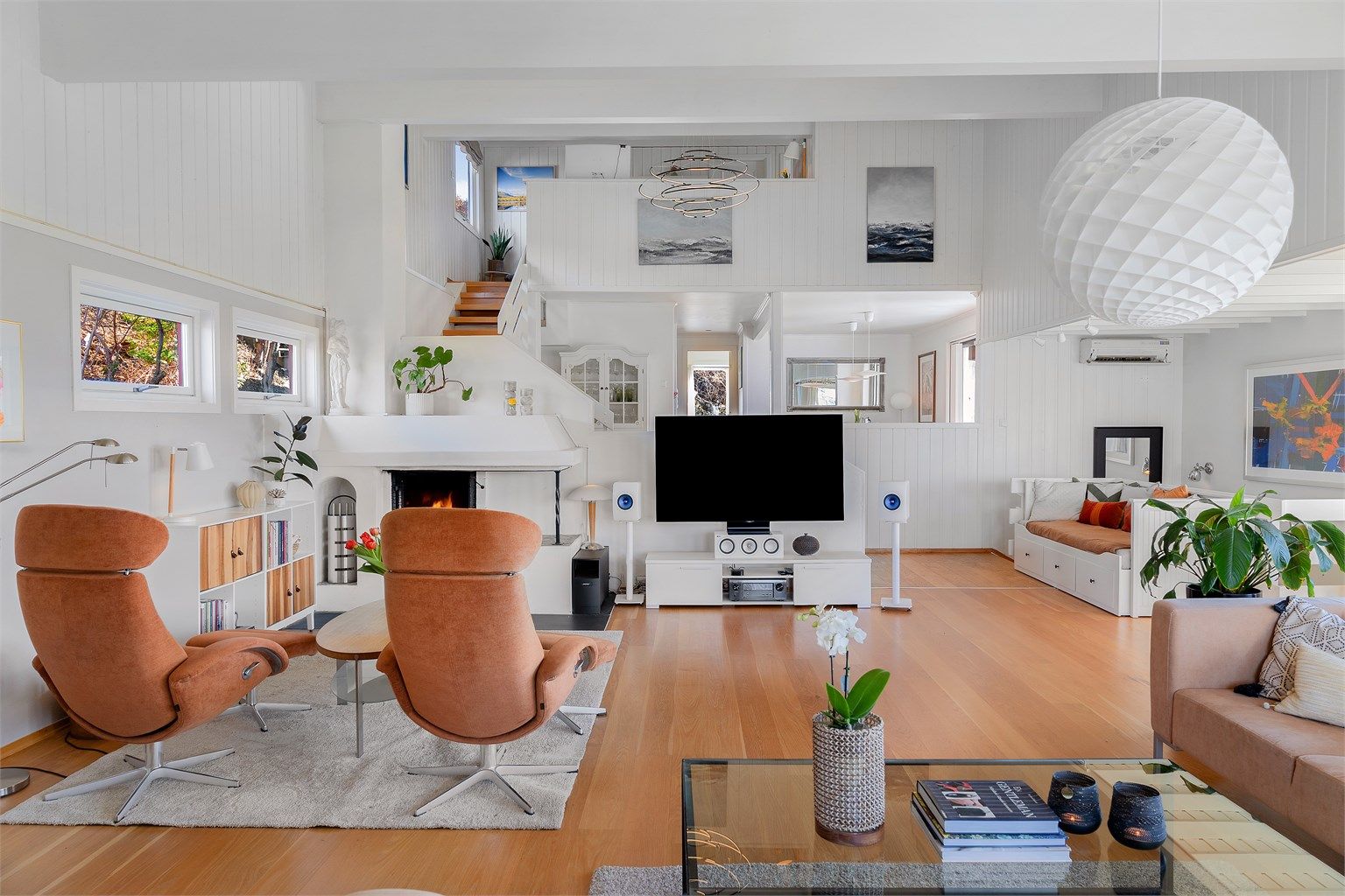 Den sentralt plasserte peisen er et naturlig samlingspunkt i den store stuen.