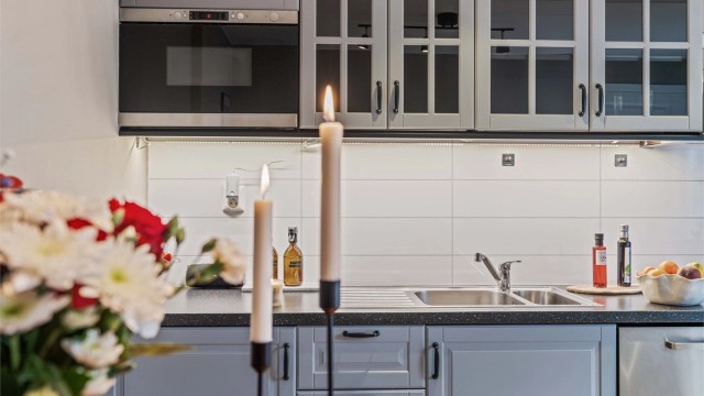 Laminert plate mellom kjøkkenbenk og overskap.