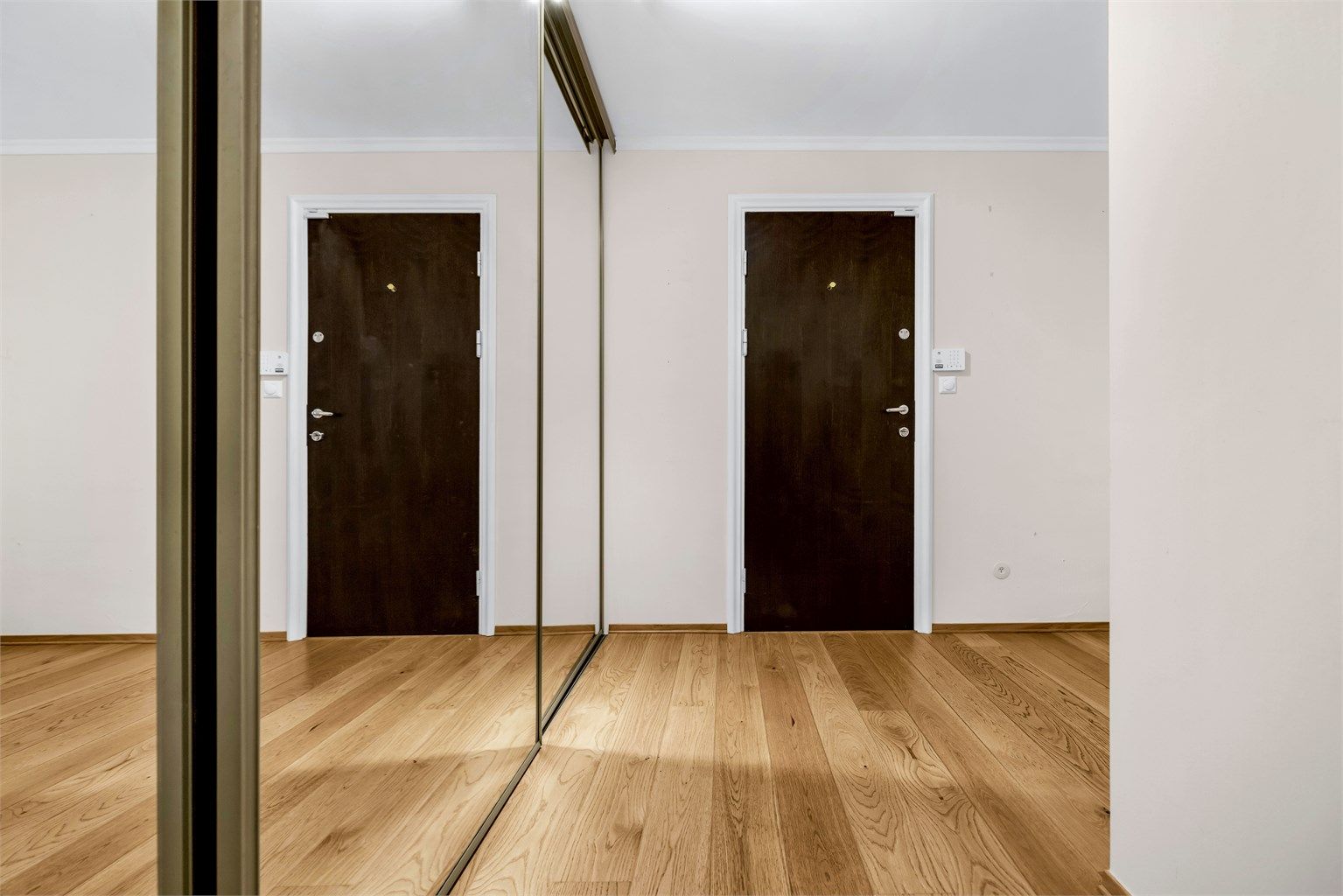 Romslig entre/hall med god plass for skooppbevaring og klesavheng i skyvedørsgarderobe med speilfronter.