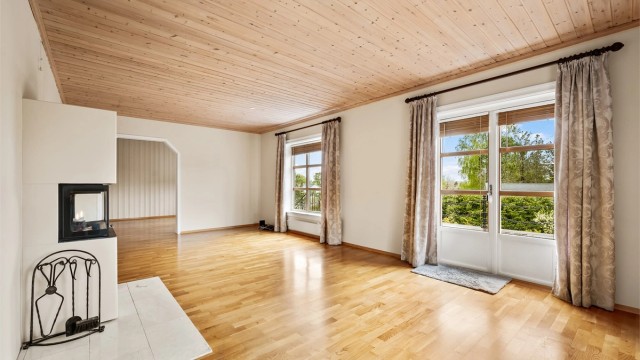 Nyere peisinnsats med flislagt gulv, pent plassert i midten av rommet.