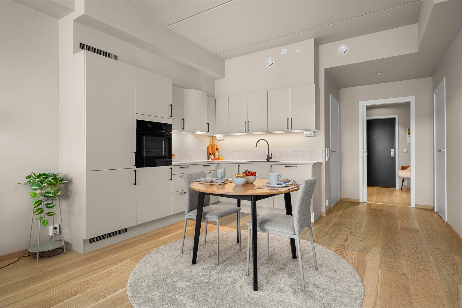 Kjøkkenet ligger naturlig tilbaketrukket fra stuen og er innredet med lyse slette flater og benkeplate av laminat. 