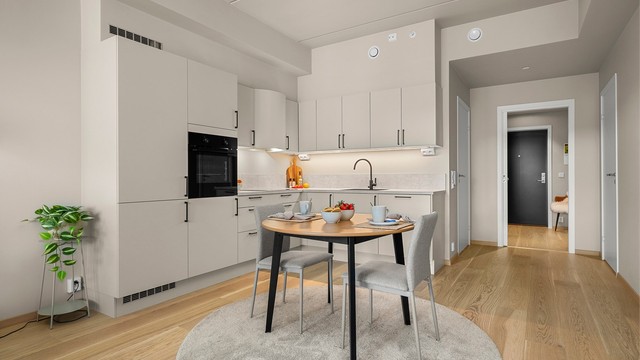 Kjøkkenet ligger naturlig tilbaketrukket fra stuen og er innredet med lyse slette flater og benkeplate av laminat.