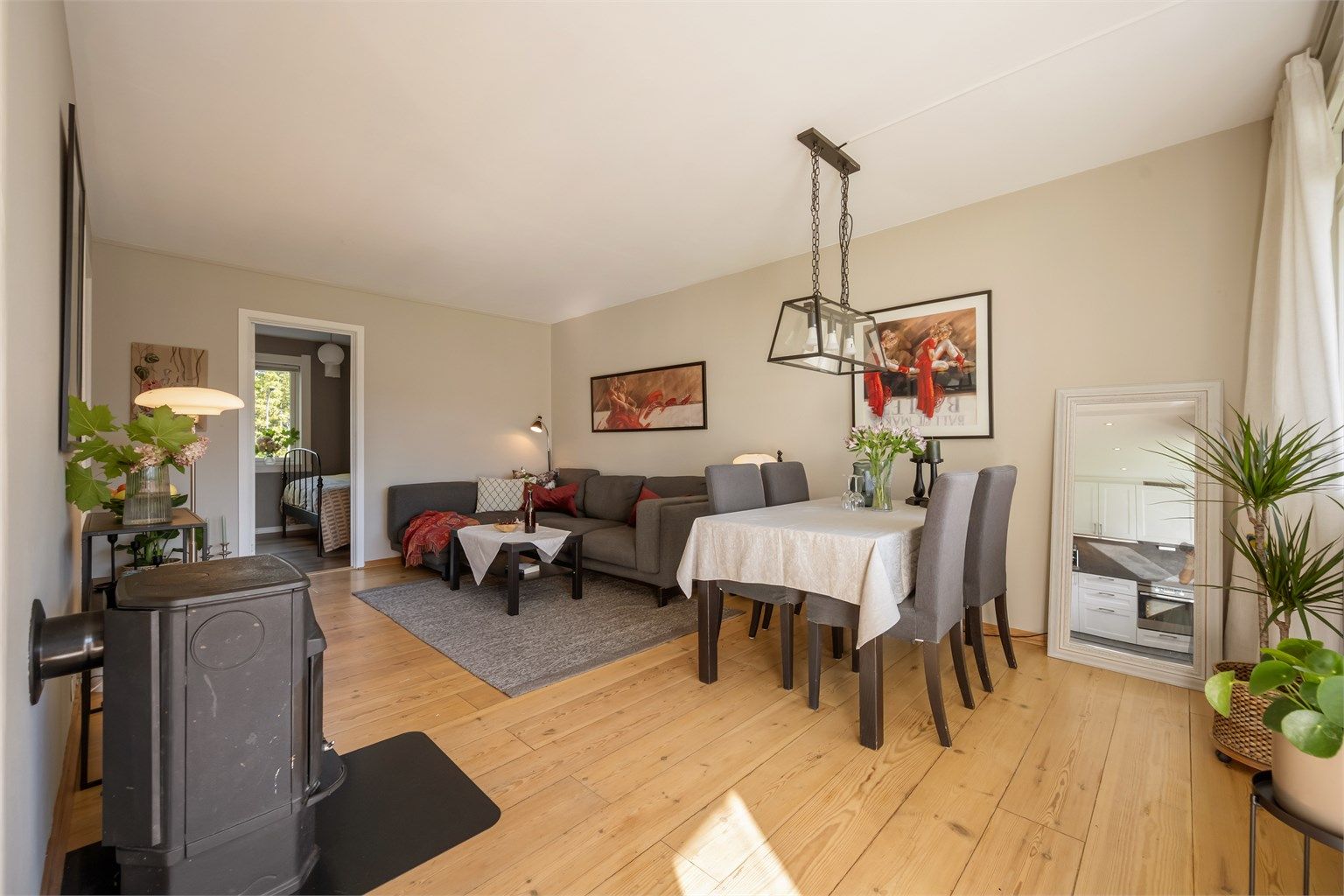 Peisovnen med glassdør er fint plassert mellom stue og kjøkken og gir både varme og et naturlig blikkfang i rommet.
