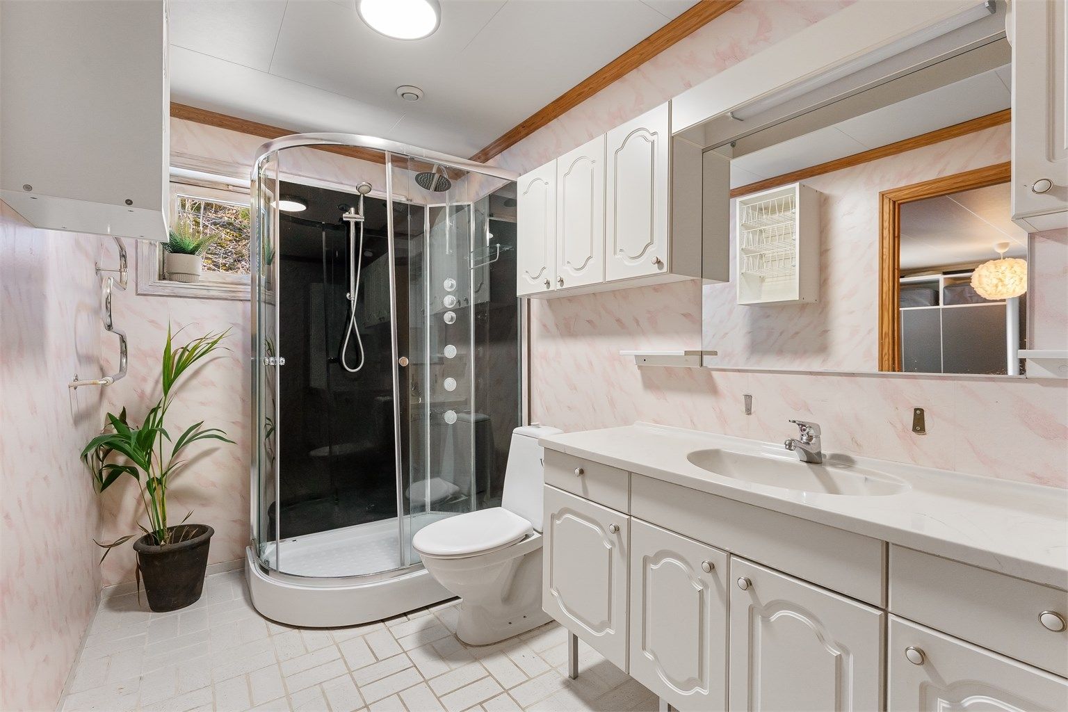 Badet i første etasje er fra byggeåret og har flislagt gulv med gulvvarme og dusjkabinett.