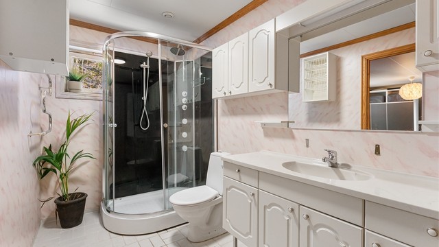 Badet i første etasje er fra byggeåret og har flislagt gulv med gulvvarme og dusjkabinett.