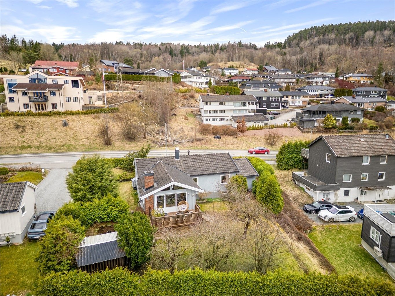 Svakt skrånende tomt som opparbeidet med skjermende hekker og et frodig hageområde.