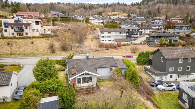 Svakt skrånende tomt som opparbeidet med skjermende hekker og et frodig hageområde.