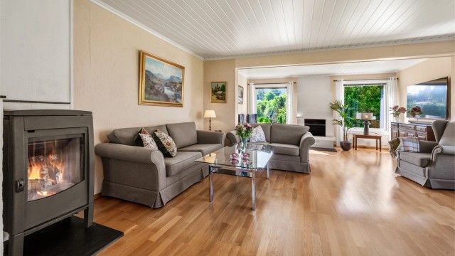 Lys og luftig stue med to sittegrupper, sofaområde samt spiseplass.