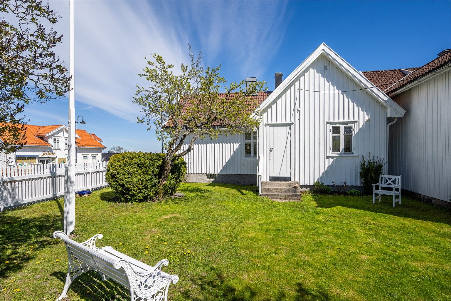 Hagen er pent opparbeidet med plen, syriner og egen flaggstang.