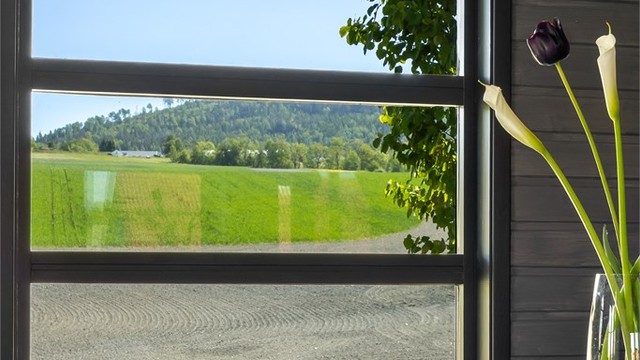 Store vindusflater rammer inn utsikten mot det omkringliggende landskapet.
