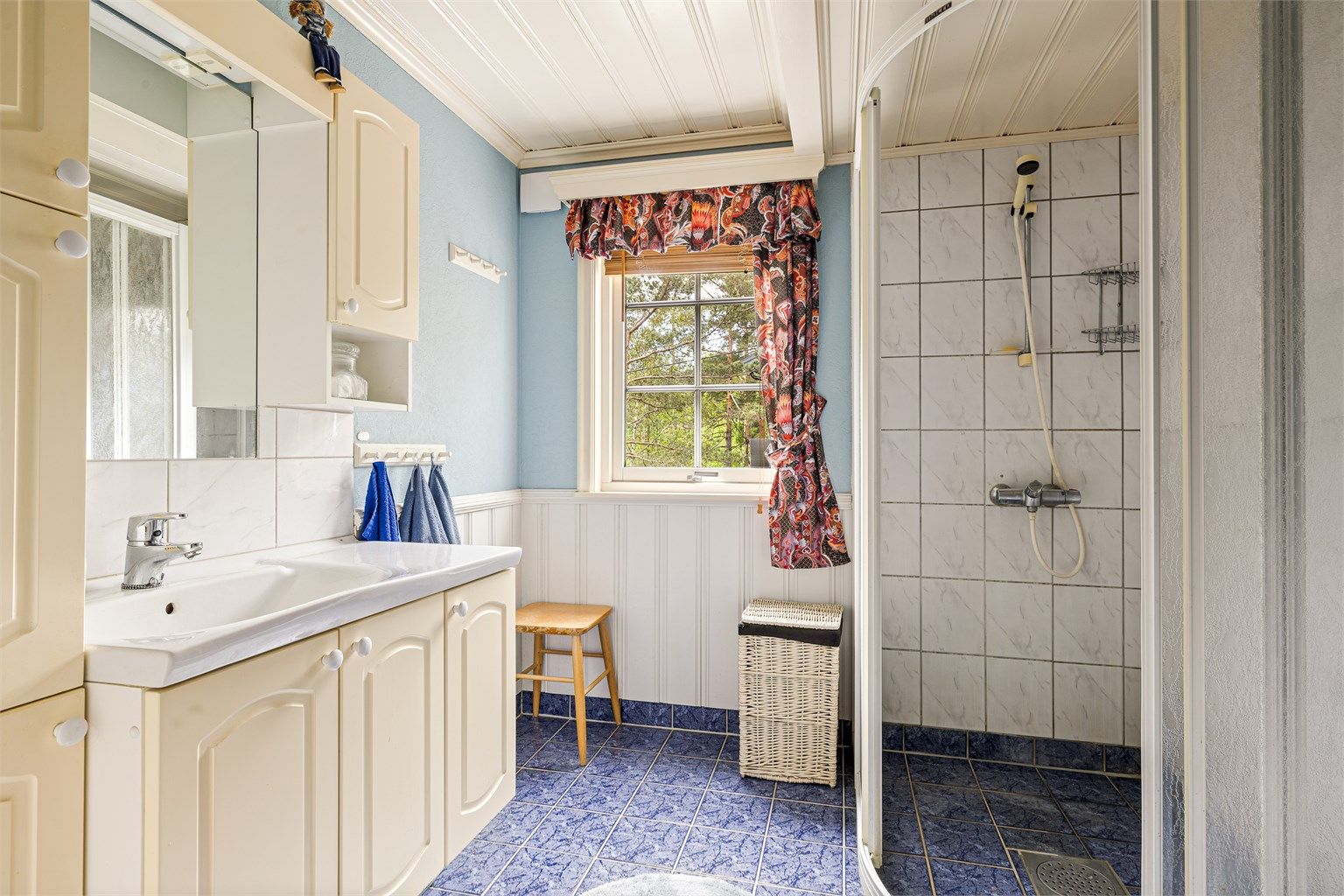 Baderommet er utstyrt med wc, servant, skap og dusjhjørne.