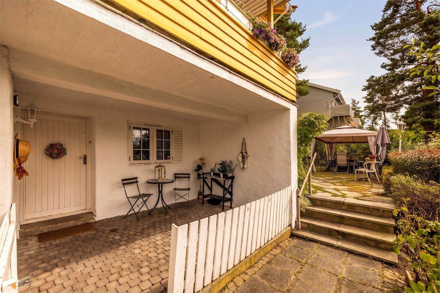 Det er separat inngang til kjelleretasjen fra steinsatt uteplass.