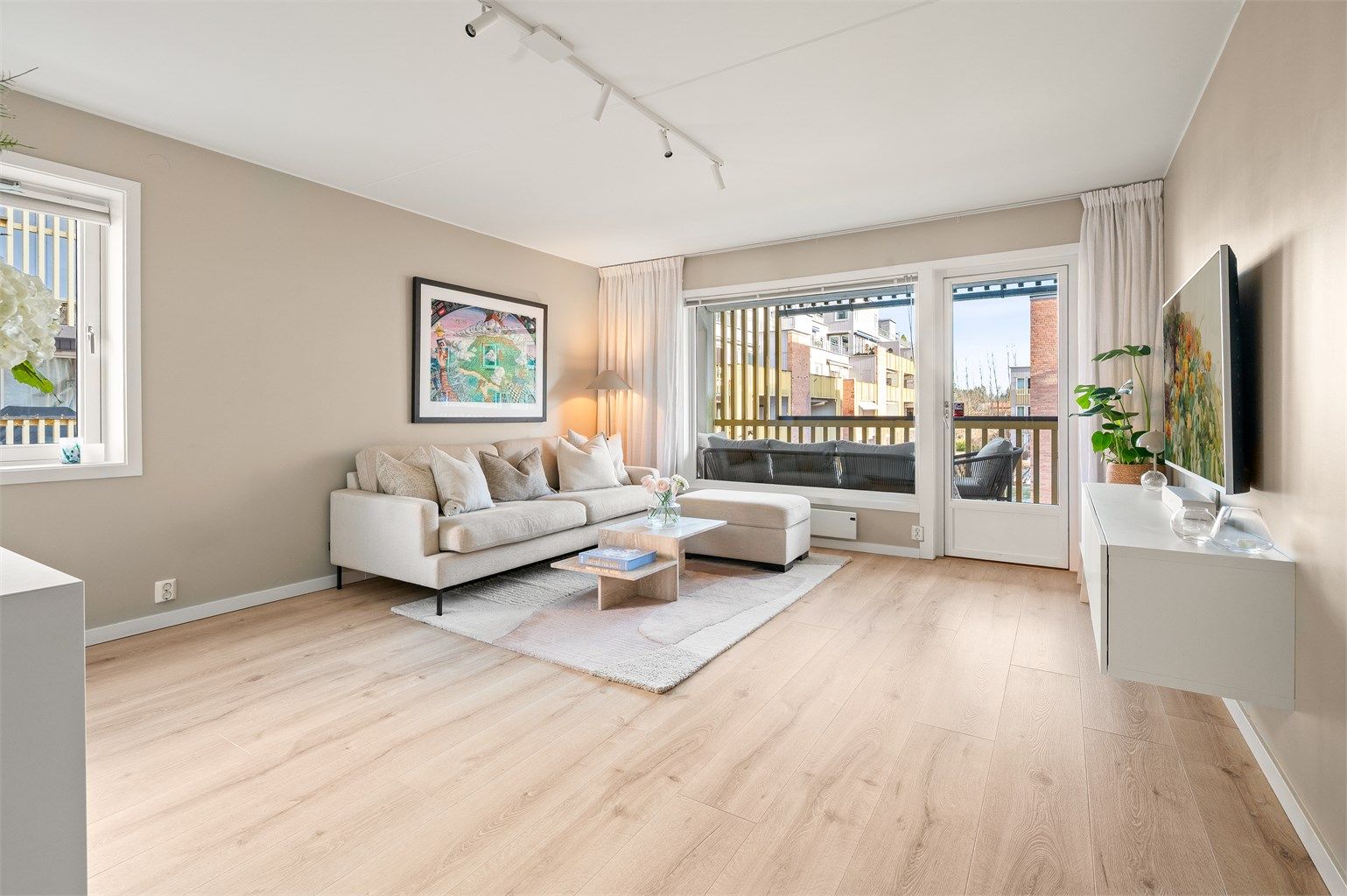 Gjennomgående laminatgulv og malte overflater gir et helhetlig og moderne inntrykk.