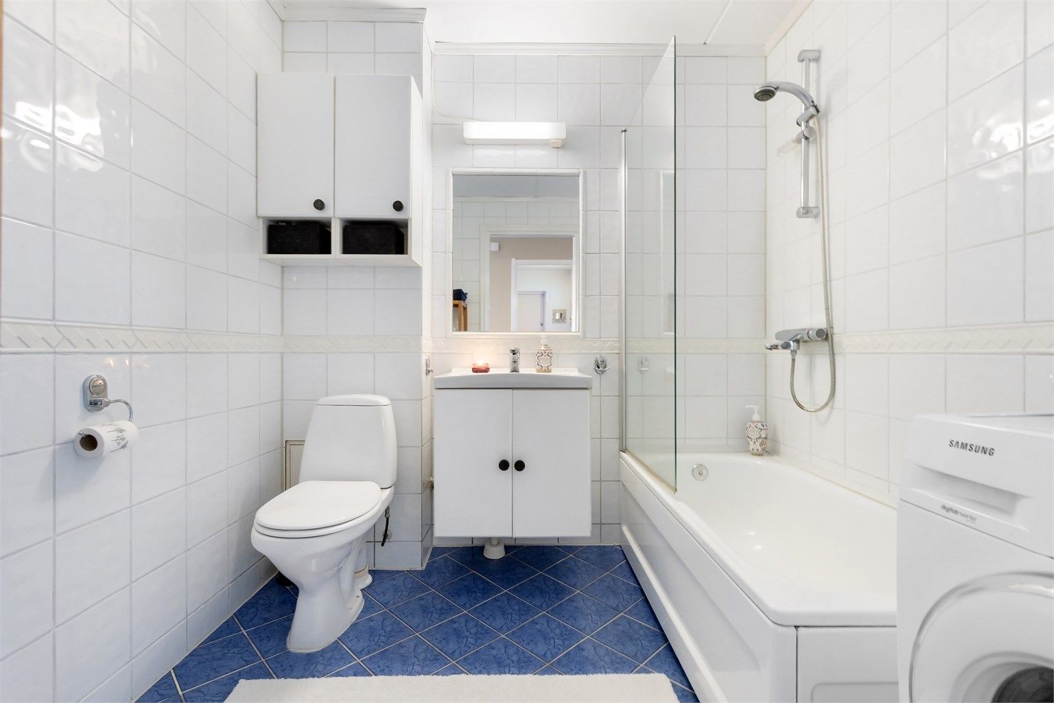 Baderom med fliser på gulv med gulvvarme, fliser på vegger og malt betonghimling