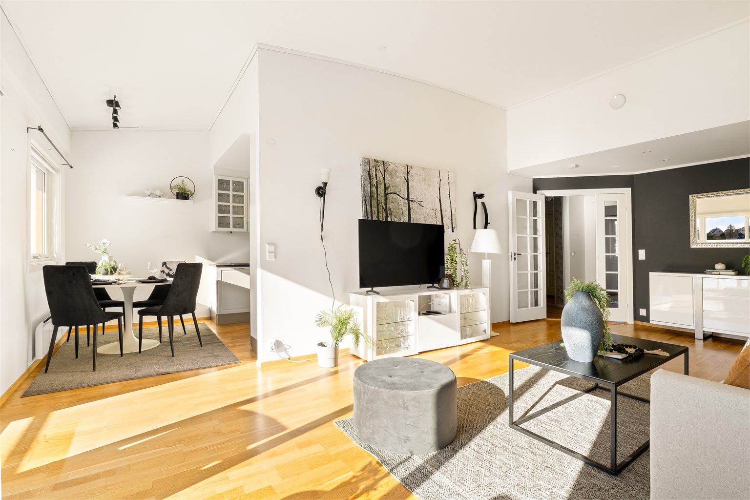 Delvis åpen løsning mellom stue og kjøkken med plass til spisegruppe.