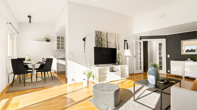 Delvis åpen løsning mellom stue og kjøkken med plass til spisegruppe.