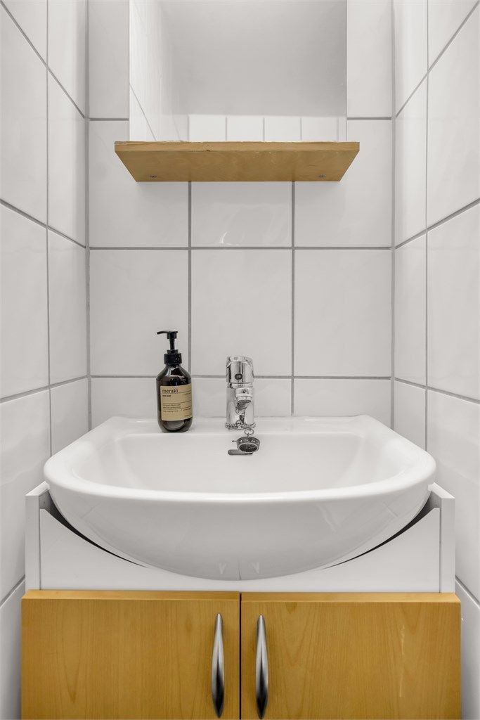 Badet er utstyrt med vegghengt servantinnredning og speil med overlys og stikkontakt over vasken. 