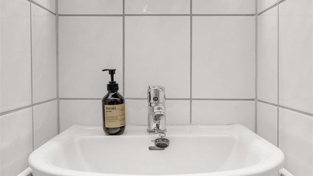 Badet er utstyrt med vegghengt servantinnredning og speil med overlys og stikkontakt over vasken.