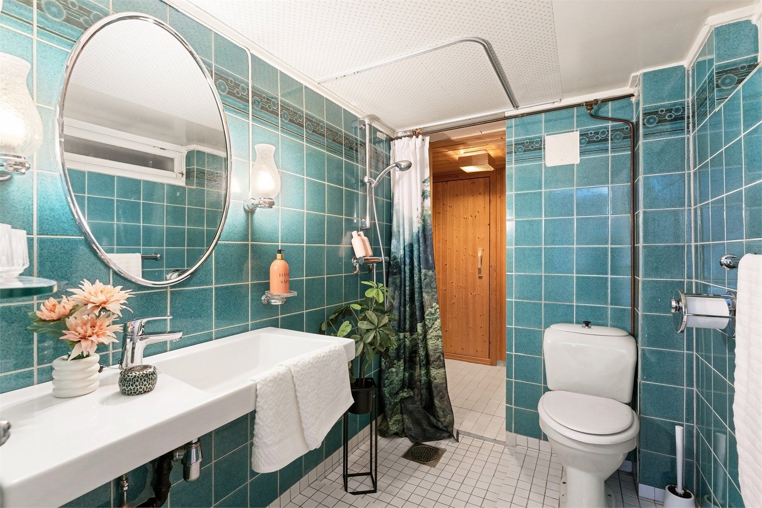 Badet i kjelleren har flislagt gulv med gulvvarme og dusjhjørne.