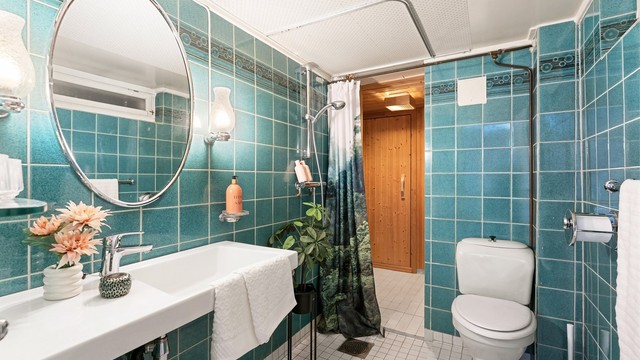 Badet i kjelleren har flislagt gulv med gulvvarme og dusjhjørne.