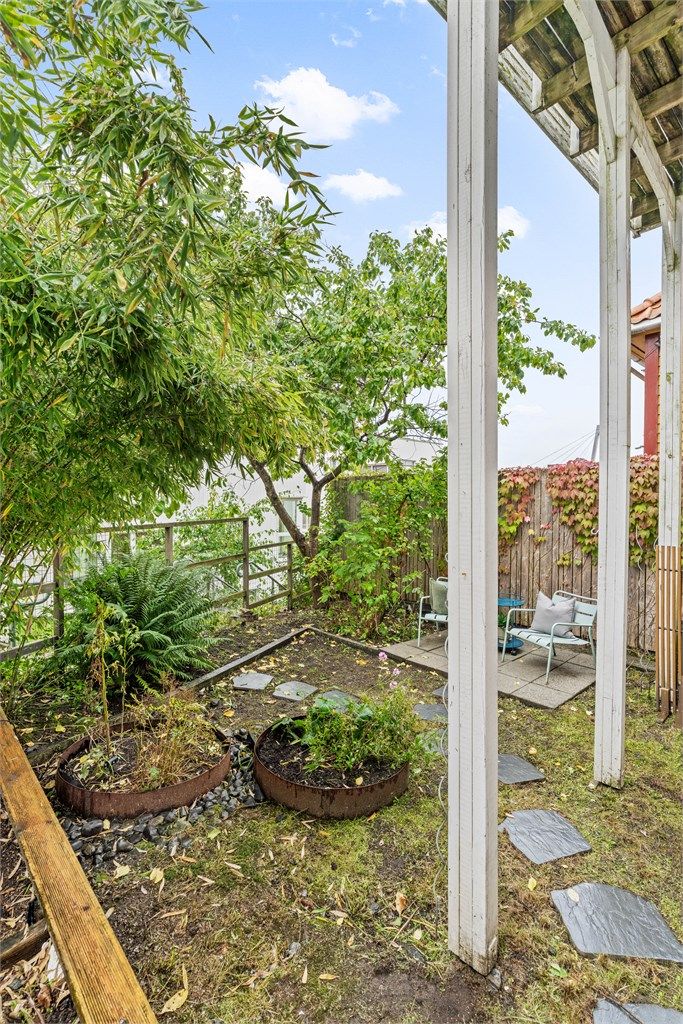 Runde plantekasser og variert beplantning skaper en frodig atmosfære i hagen.