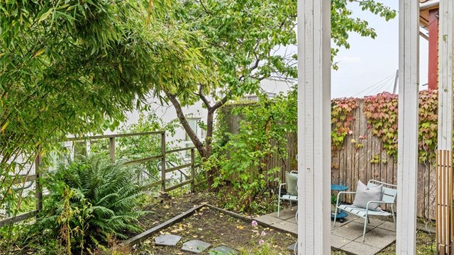Runde plantekasser og variert beplantning skaper en frodig atmosfære i hagen.