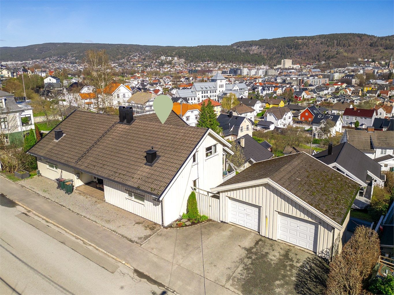 Eiendommen har en god plassering på tomten med garasje og biloppstillingsplass ved adkomsten.