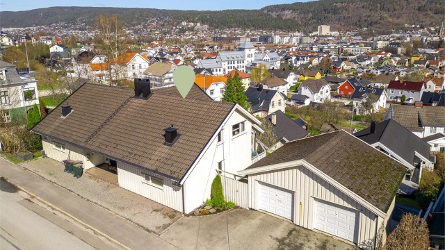 Eiendommen har en god plassering på tomten med garasje og biloppstillingsplass ved adkomsten.