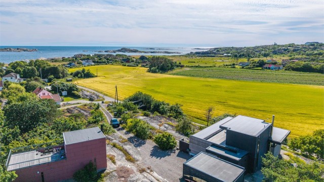 Boligen er fundamentert direkte på fjellet, og kombinasjonen av betong, tre og store glassflater skaper en unik dialog med den omkringliggende naturen og havet.