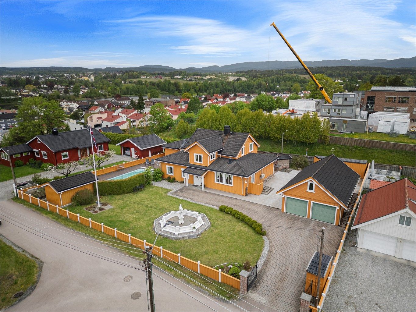 Pen eiendom omkranset av gjerde og støyskjerm mot Østre Brugate. Eiendommen ligger høyere enn veien og har derfor i tillegg naturlig skjerming.