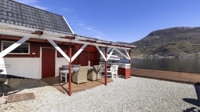 Ved naustet er det en overbygget uteplass med platting.