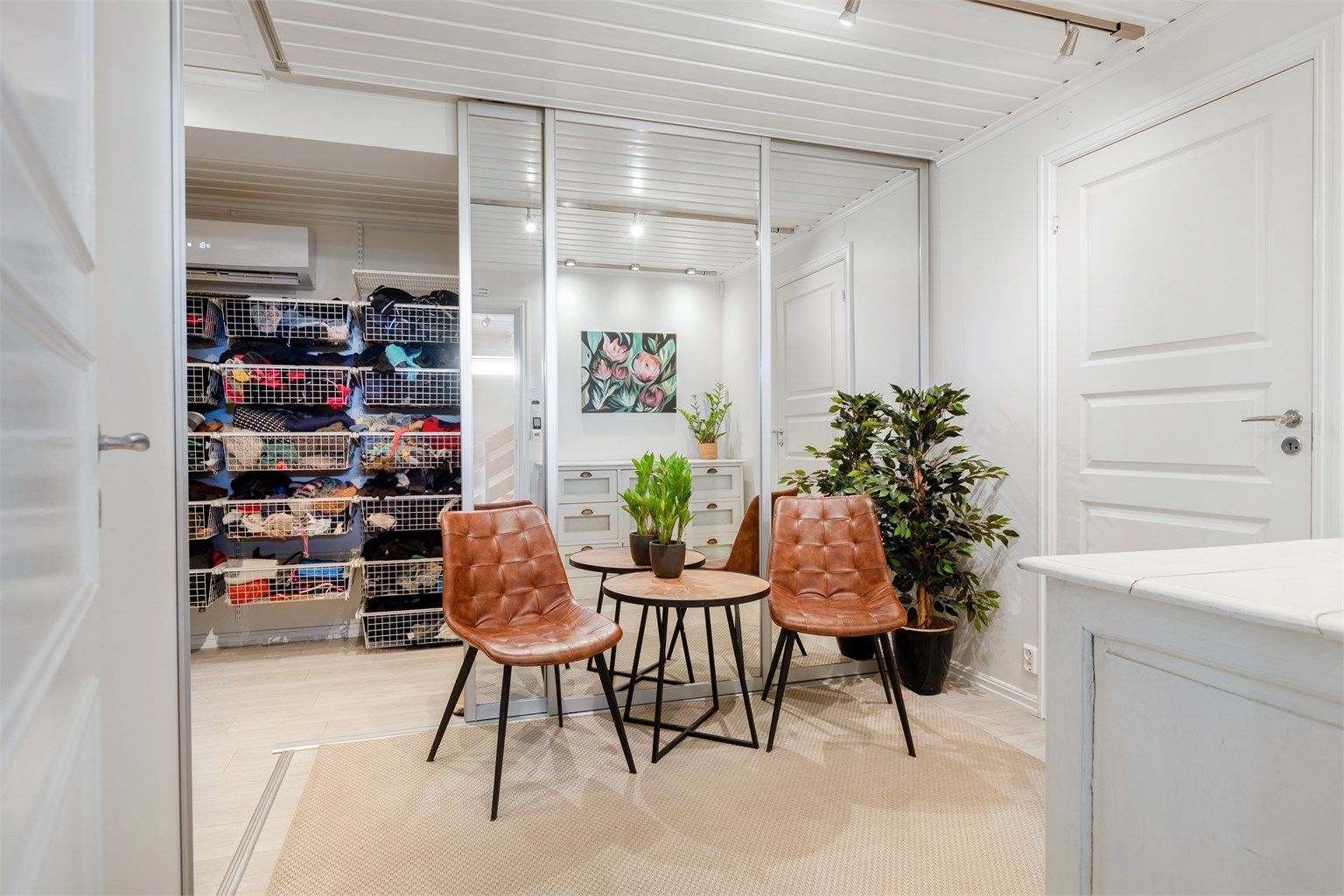 Praktisk rom benyttet som garderoberom, med skyvedørsgarderobe og en nyere varmepumpe fra 2023 som sikrer et behagelig inneklima.