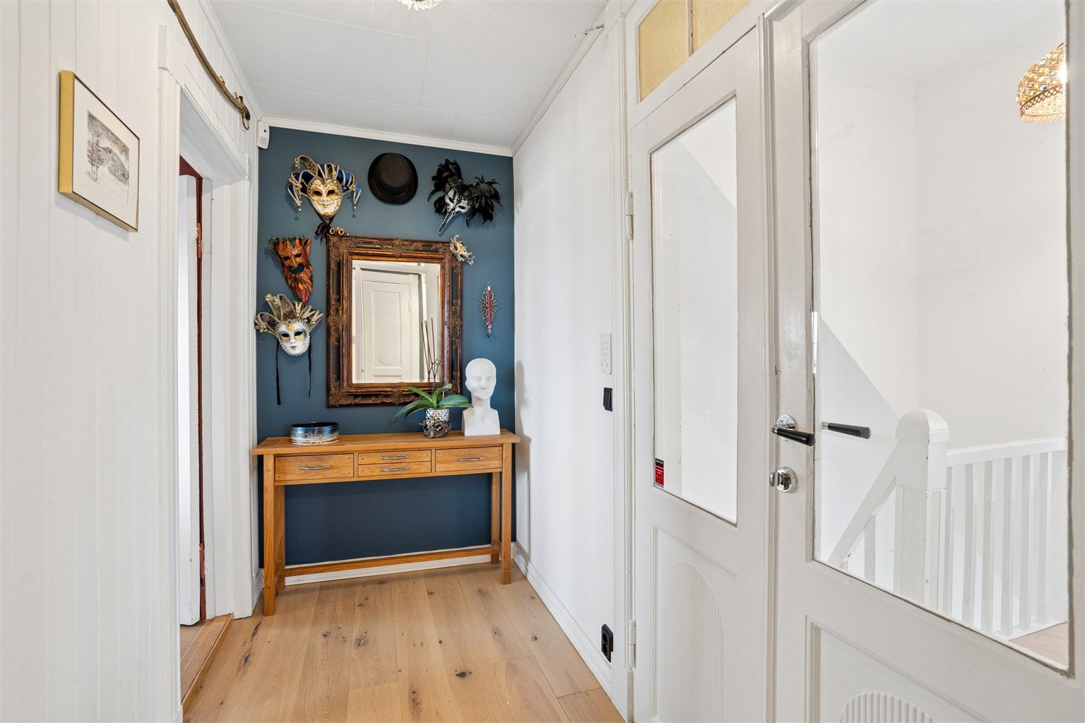 Entréen har parkett på gulvet og en original dør med glassfelt.