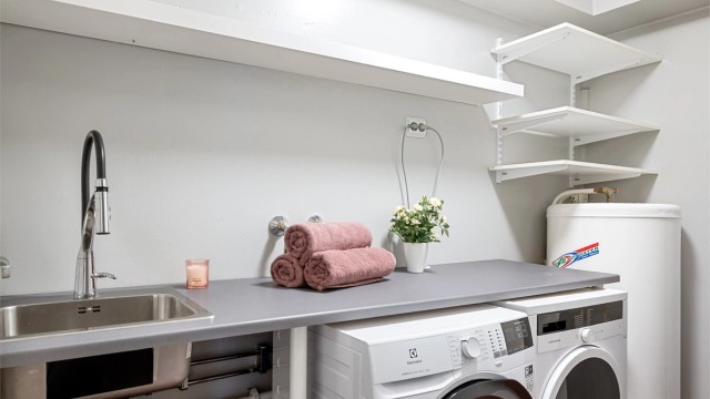 Romslig og praktisk vaskerom. Her er det gulvbelegg fra byggeår