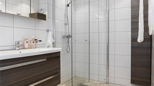 Badet i 1. etasje ble renovert i 2016 med fliser, gulvvarme og innfellbare glassdører.