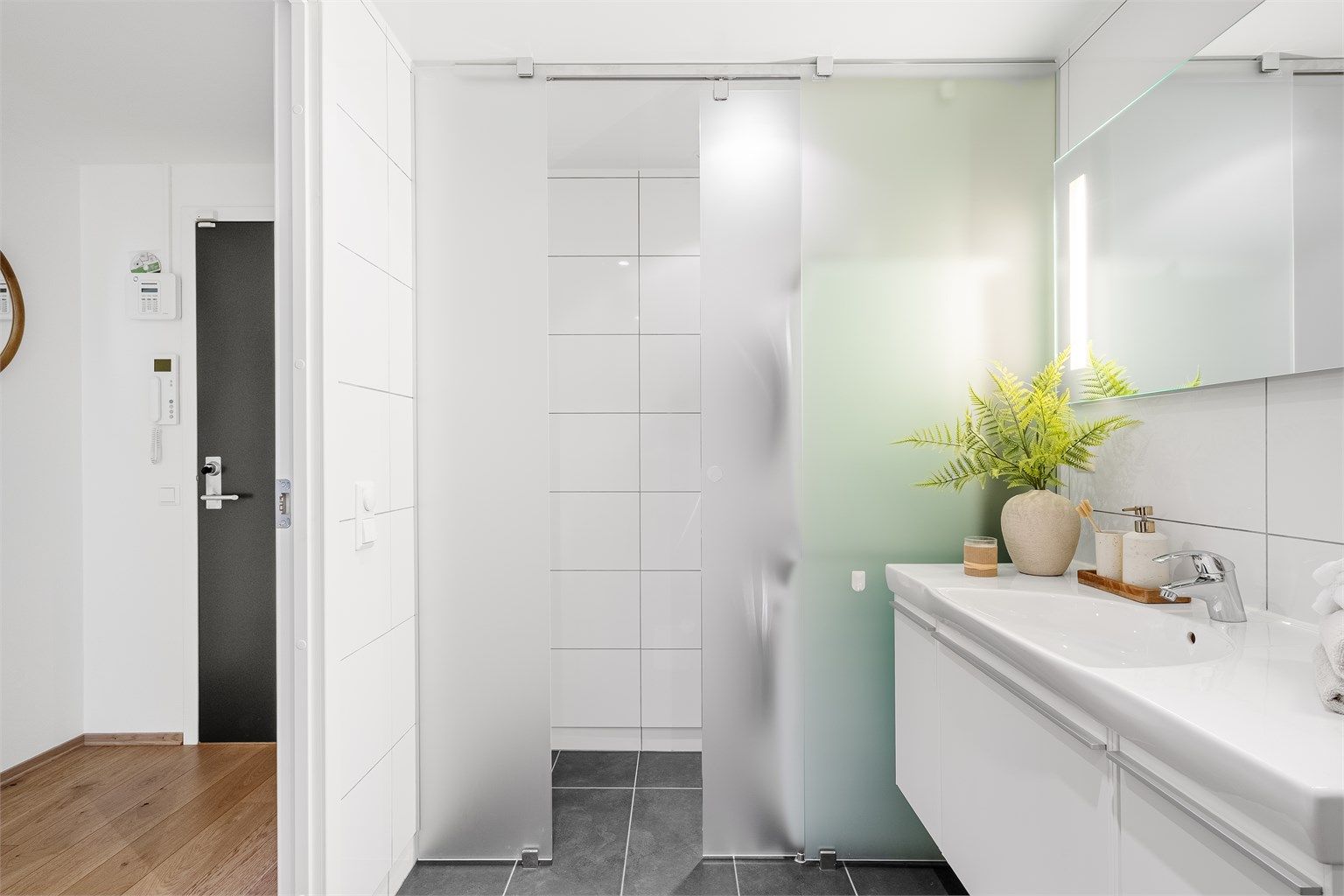 Opplegg for vaskemaskin og plass til tørketrommel, som er smart plassert bak en frostet glassvegg. Spotter i tak. 
Det er kommentarer til badet, les under takst og tilstand. 