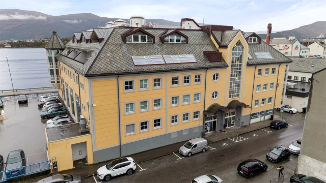 Fasader i kombinasjon av malt murpuss og trekledning med inngangsparti mot Sundgata.