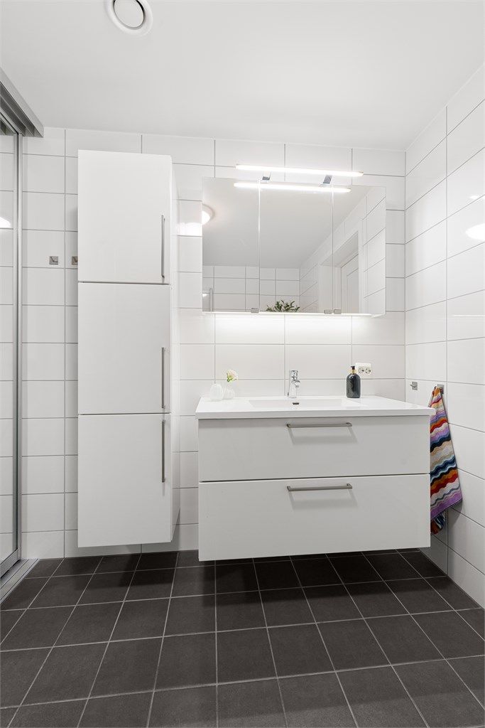 Innredning med nedfelt servant, vegghengt skap, speilskap med overlys og stikkontakter over servant og i speilskap