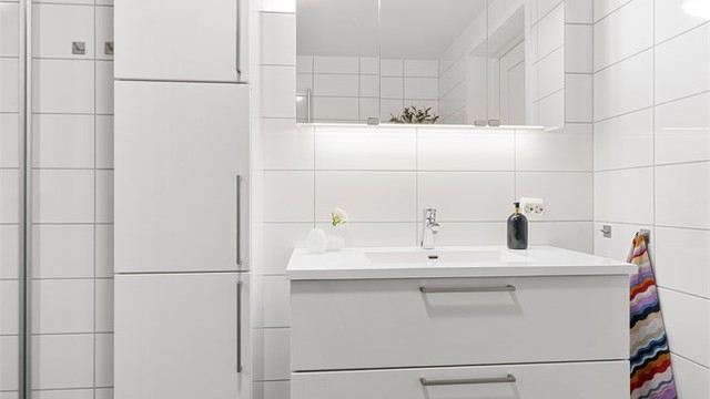 Innredning med nedfelt servant, vegghengt skap, speilskap med overlys og stikkontakter over servant og i speilskap