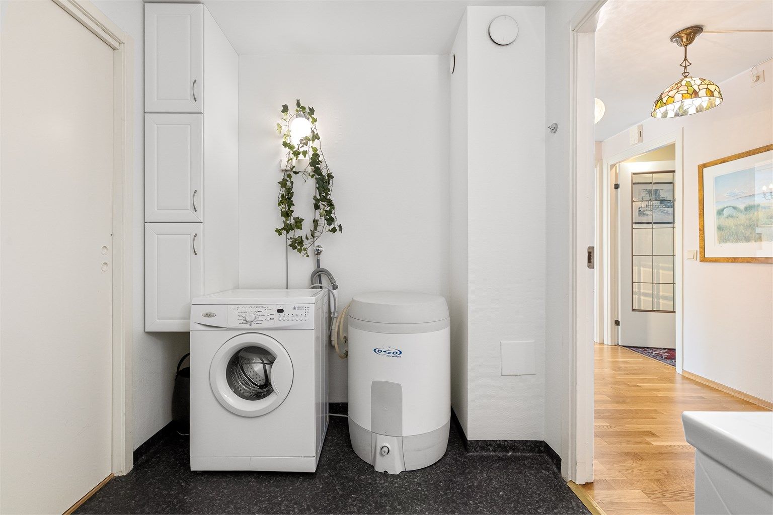 God plass til både vaskemaskin og ekstra oppbevaring på dette romslige badet. Skyvedøren til venstre er ikke i bruk i dag, men leder til soverom/bibliotek.