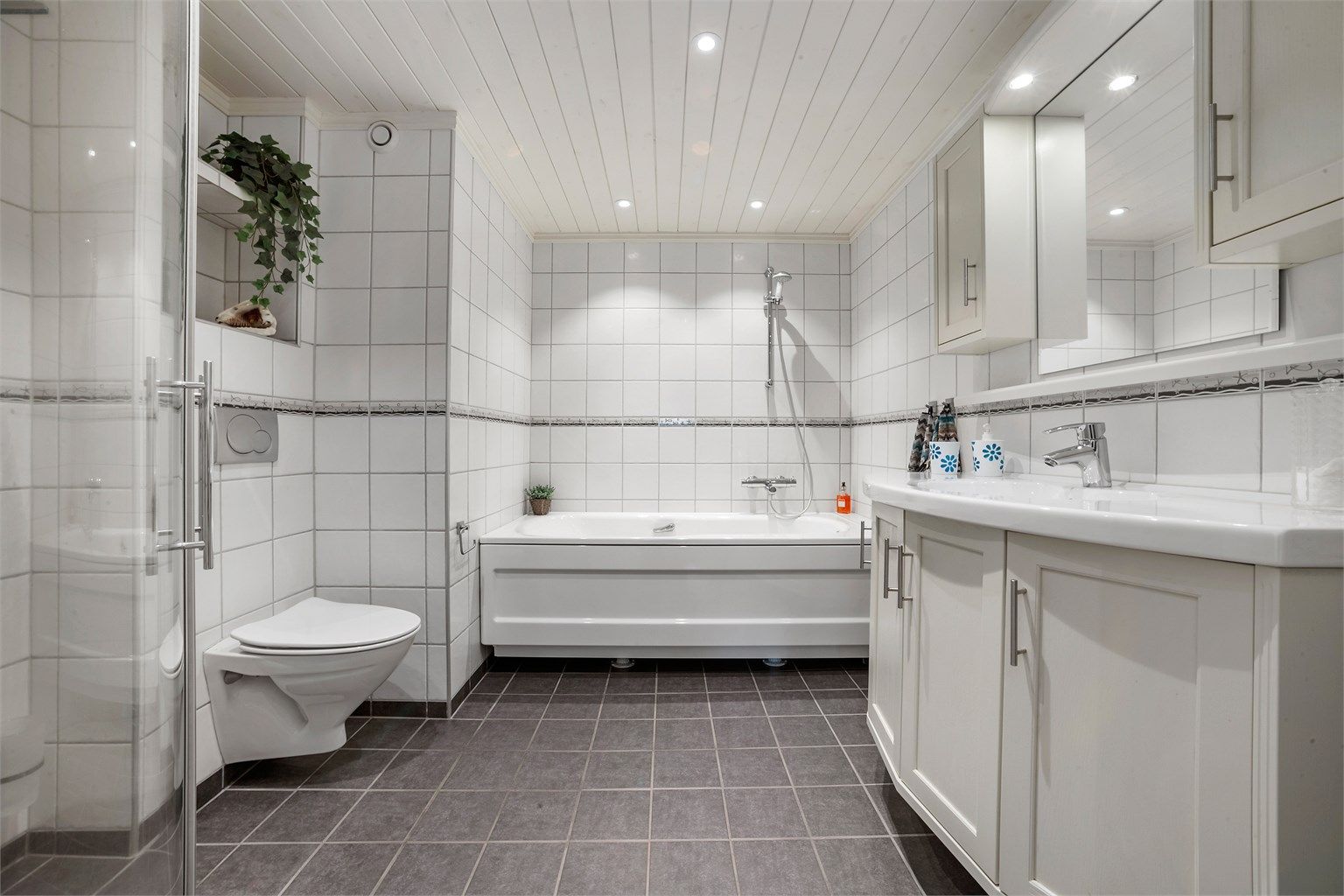 Baderom fra 2009 med flislagte flater og gulvvarme.