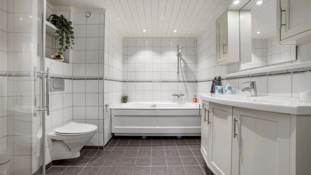 Baderom fra 2009 med flislagte flater og gulvvarme.