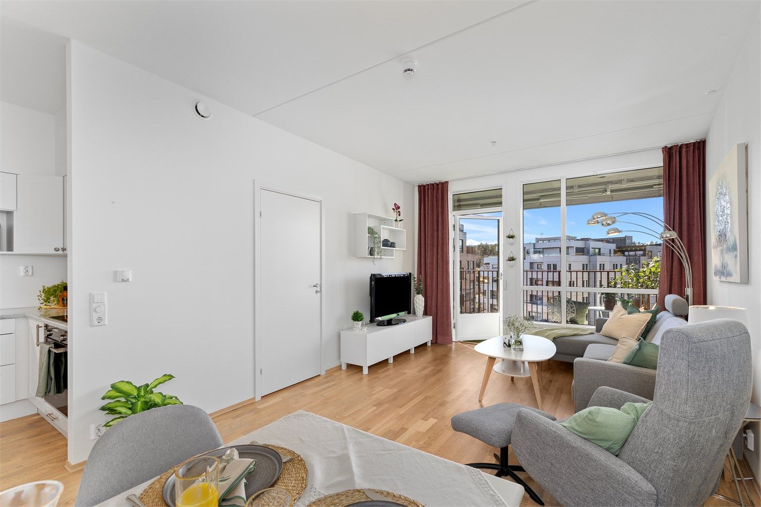 Den åpne løsningen mellom stue og kjøkken gir en fin flyt i leilighetens sosiale sone.